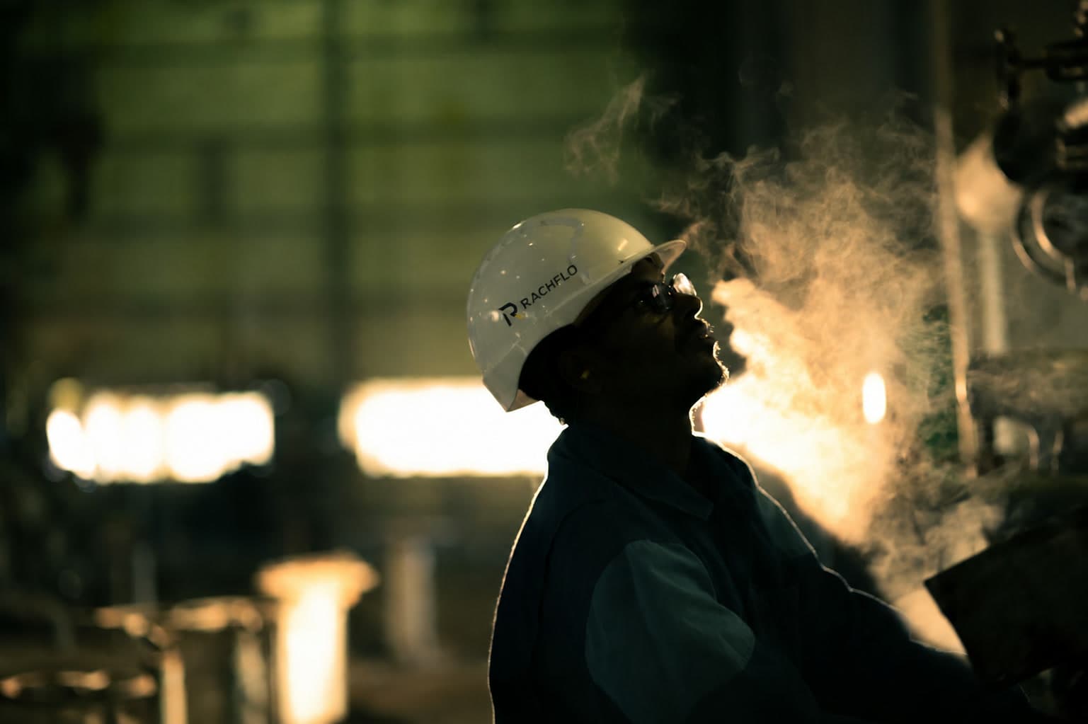 Technician in a hard hat on an oil and gas facility